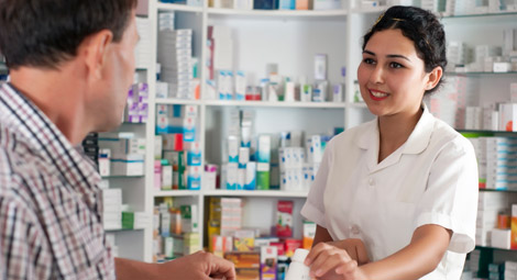 Pharmacist stood in front of shelves of medication